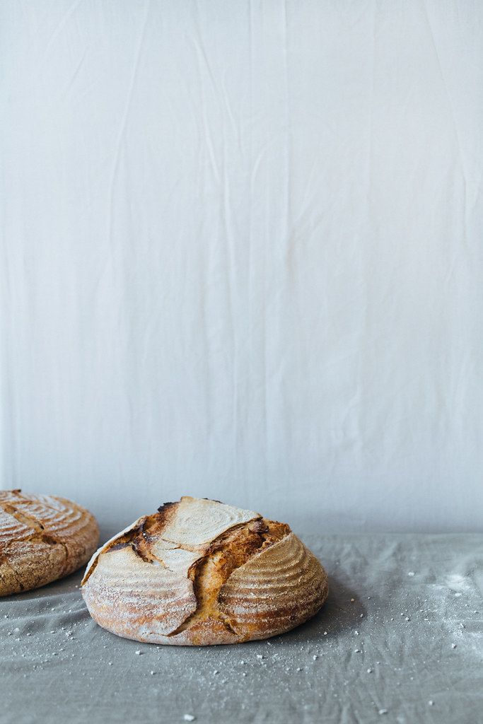 Sourdough loaf with an open ear on a gray linen tablecloth