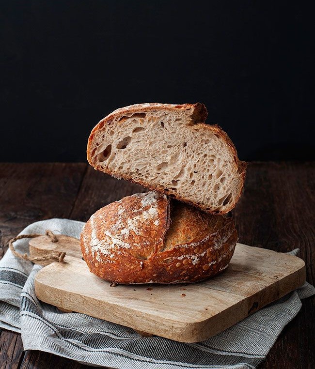 Sliced sourdough loaf showing its crumb on a wooden board