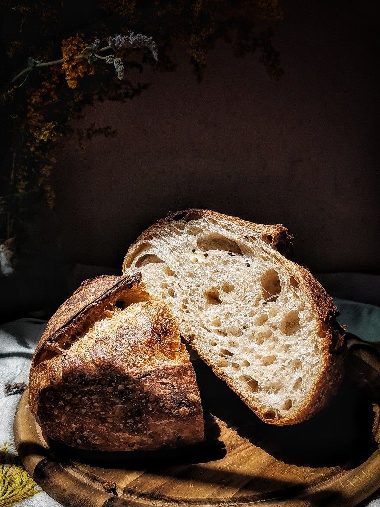 Halved sourdough loaf showing its open, airy crumb
