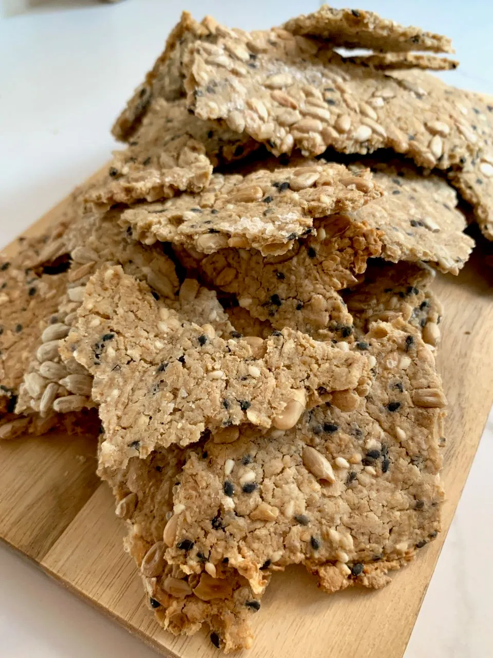 Crunchy seed and sourdough crackers on a wooden board