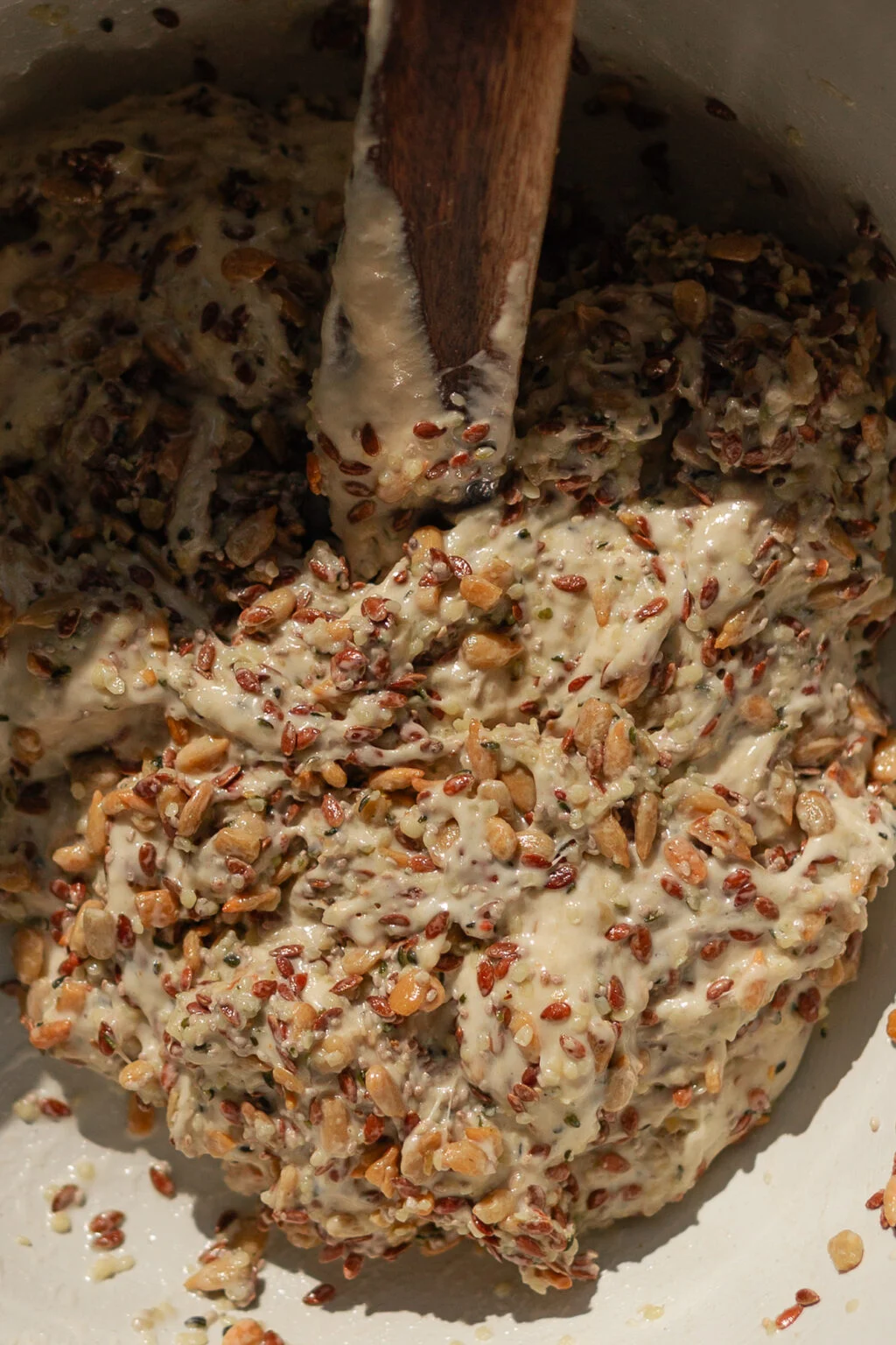 Thick seed and sourdough mixture with a wooden spoon